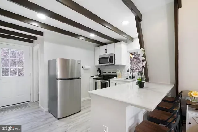 a kitchen with a refrigerator a stove a microwave and cabinets