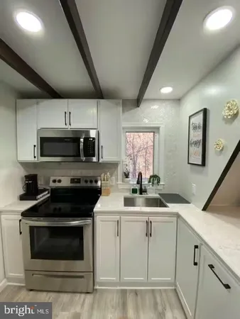 a kitchen with granite countertop a sink stainless steel appliances and cabinets