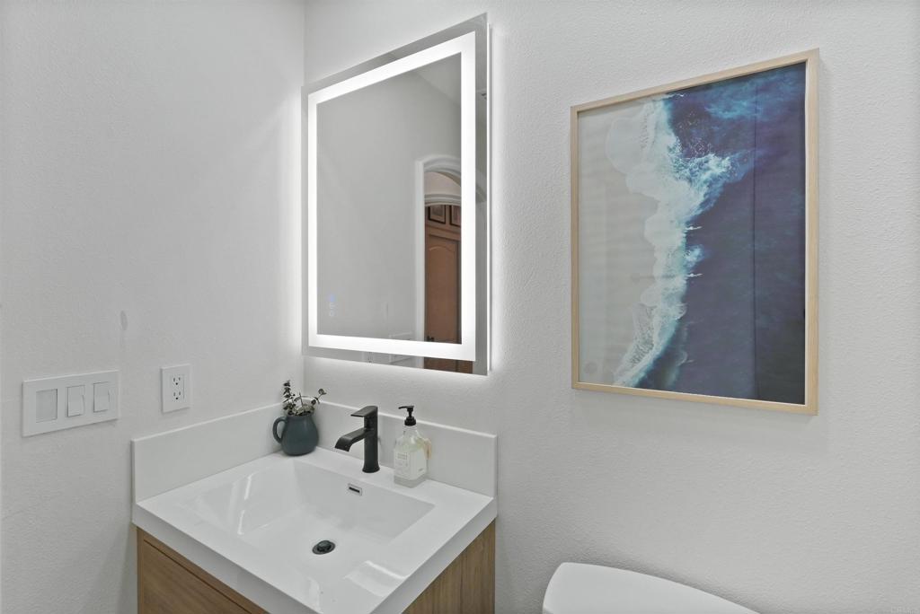 25351 Forest Street Corona, CA 92883 - Photo 44 of 72 a bathroom with a sink and mirror with toilet