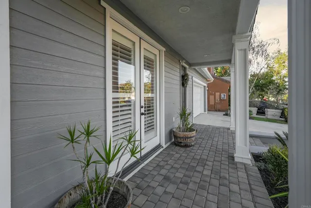 a front view of a house with a garden and trees