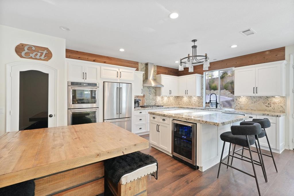 25351 Forest Street Corona, CA 92883 - Photo 6 of 72 a kitchen with white cabinets and stainless steel appliances