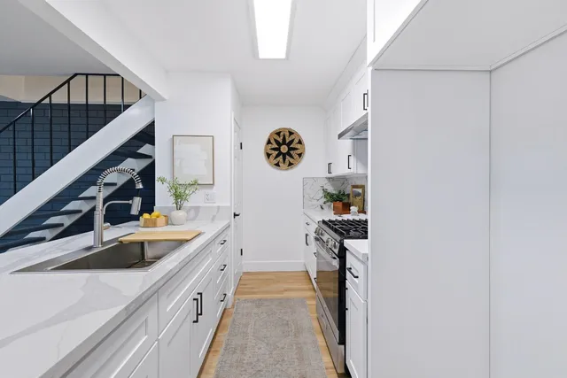 a hallway with sink and cabinets