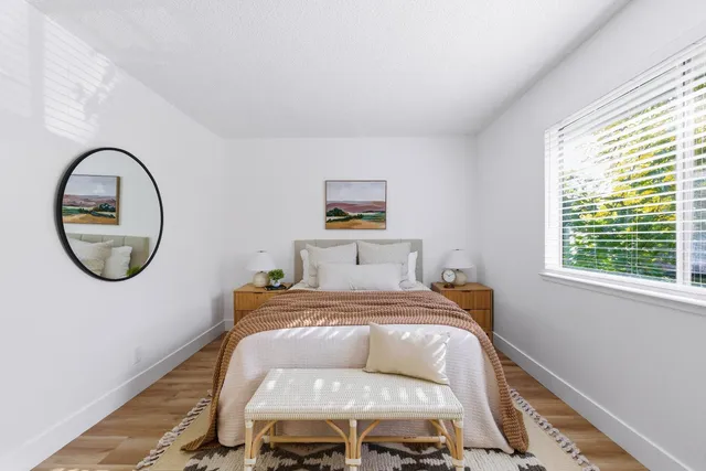 a bed sitting in a bedroom next to a window
