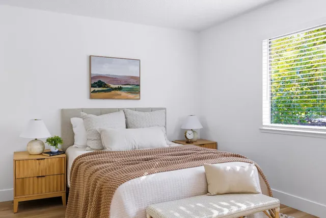 a bedroom with a bed and a painting on the wall