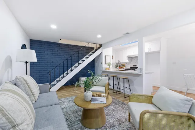 a living room with furniture and a wooden floor