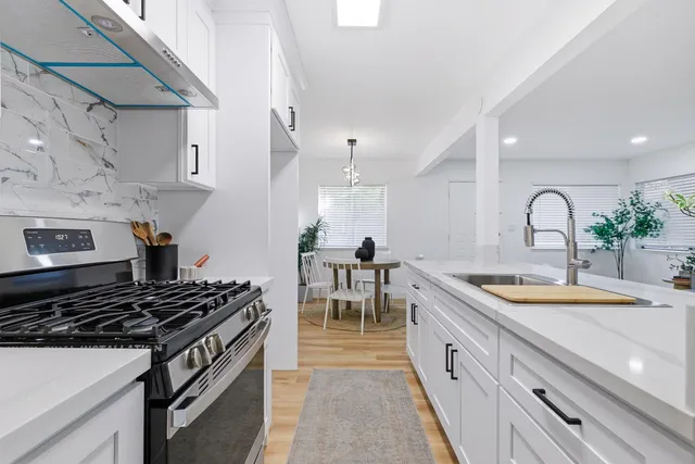 a kitchen with sink stove and cabinets