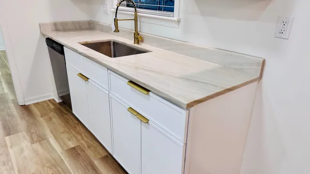 a kitchen with a sink and wooden floor