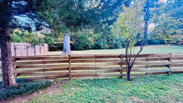 a view of a yard with wooden fence