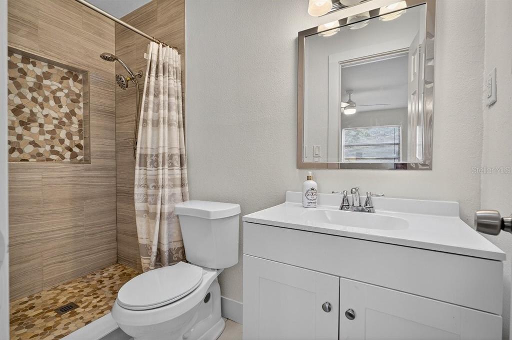 450 Lambert Avenue Flagler Beach, FL 32136 - Photo 11 of 41 a bathroom with a toilet sink vanity and shower