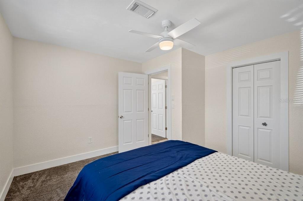 450 Lambert Avenue Flagler Beach, FL 32136 - Photo 16 of 41 a bedroom with a bed and a lamp on the dresser