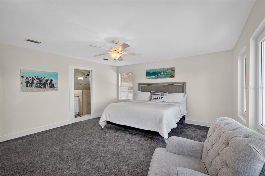 450 Lambert Avenue Flagler Beach, FL 32136 - Photo 18 of 41 a spacious bedroom with a bed and a chandelier