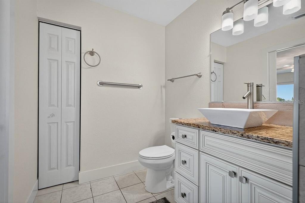 450 Lambert Avenue Flagler Beach, FL 32136 - Photo 23 of 41 a spacious bathroom with a granite countertop sink a toilet and a mirror