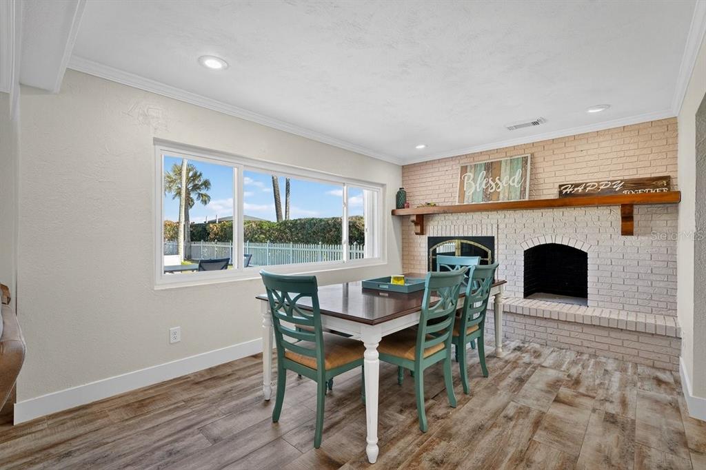 450 Lambert Avenue Flagler Beach, FL 32136 - Photo 27 of 41 a dining room with furniture a fireplace and wooden floor