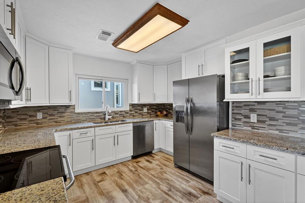 450 Lambert Avenue Flagler Beach, FL 32136 - Photo 31 of 41 a kitchen with stainless steel appliances granite countertop a refrigerator sink and stove