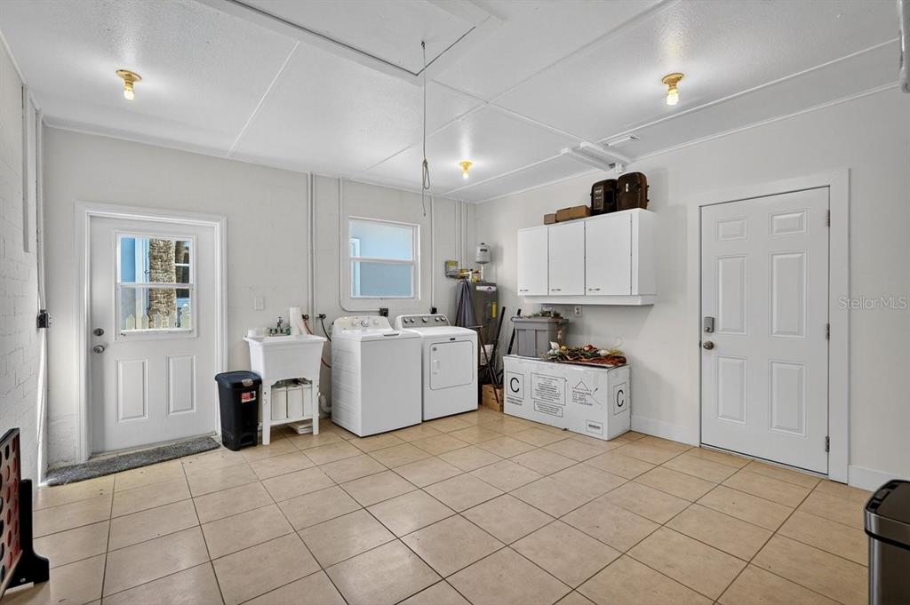 450 Lambert Avenue Flagler Beach, FL 32136 - Photo 35 of 41 a large white kitchen with cabinets a sink a window and white stainless steel appliances