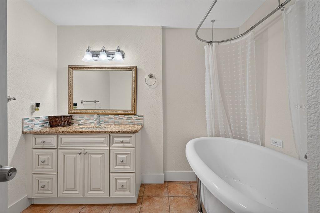 450 Lambert Avenue Flagler Beach, FL 32136 - Photo 8 of 41 a bathroom with a granite countertop sink a toilet and a mirror