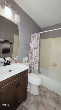 a bathroom with a sink a toilet a mirror and shower