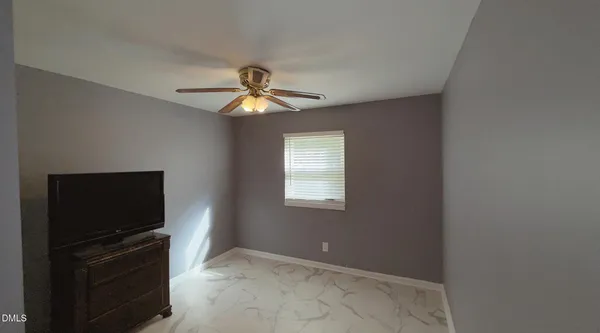 a view of a livingroom with a flat screen tv and a ceiling fan