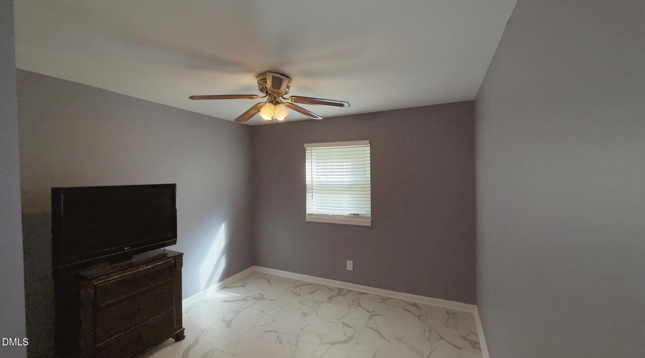 428 Walton Street Durham, NC 27703 - Photo 8 of 14 a view of a livingroom with a flat screen tv and a ceiling fan