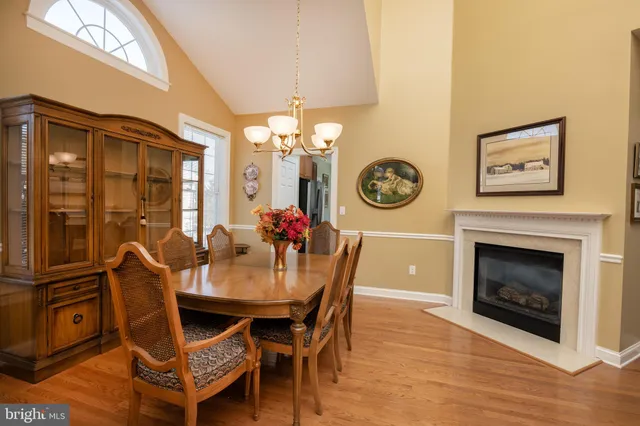 a dining room with furniture a fireplace and wooden floor