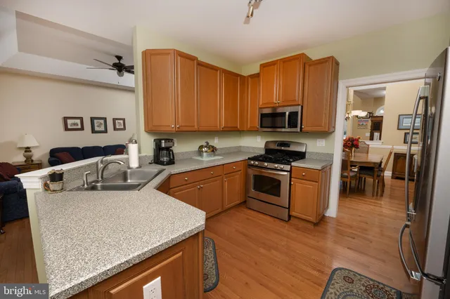 a kitchen with stainless steel appliances granite countertop a sink a stove top oven a counter space and cabinets