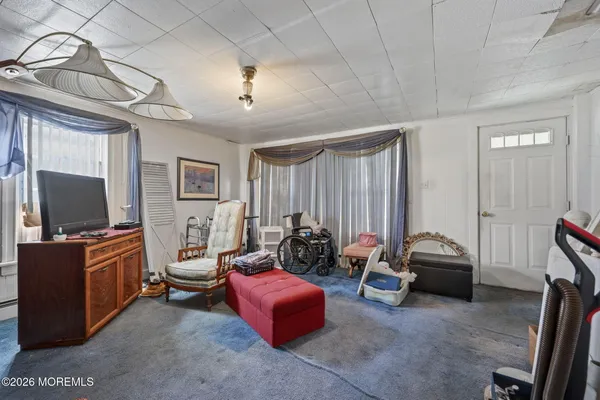 a living room with furniture a flat screen tv and gym equipment
