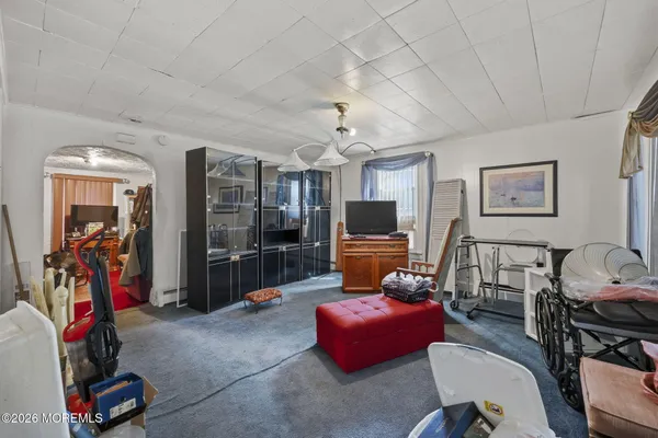 a living room with furniture a flat screen tv and a window
