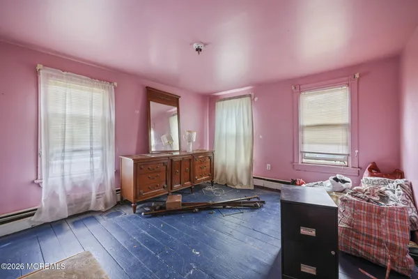 a living room with a dresser and a window