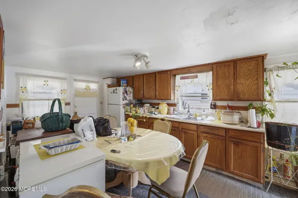 a kitchen with stainless steel appliances a stove top oven a sink a dining table and chairs