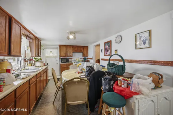 a open kitchen with stainless steel appliances granite countertop a sink dishwasher a dining table and chairs with wooden floor