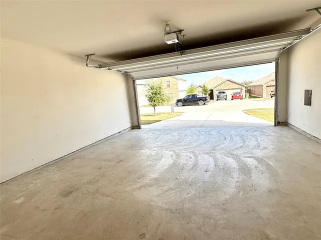 a view of an empty room with wooden floor and windows