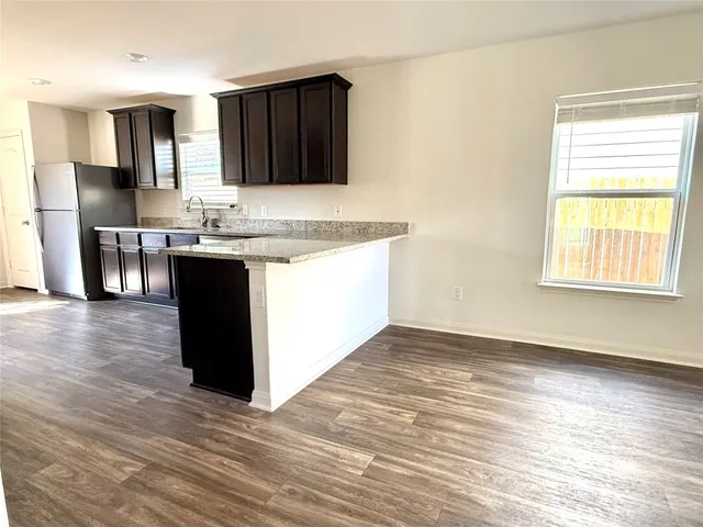 a kitchen with granite countertop a stove and a refrigerator
