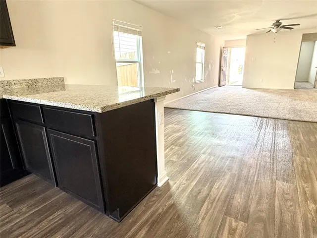 a view of kitchen living room with wooden floor and electronic appliances