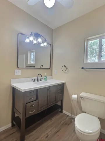 a bathroom with a toilet a sink and a large mirror