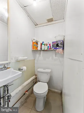 a bathroom with a toilet a sink and a mirror