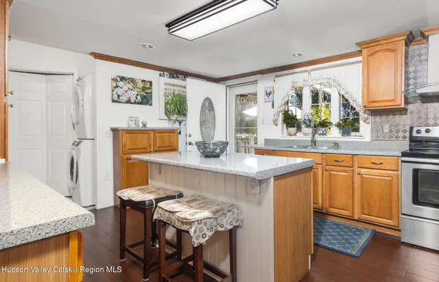 a kitchen with stainless steel appliances granite countertop a table chairs in it and wooden floors