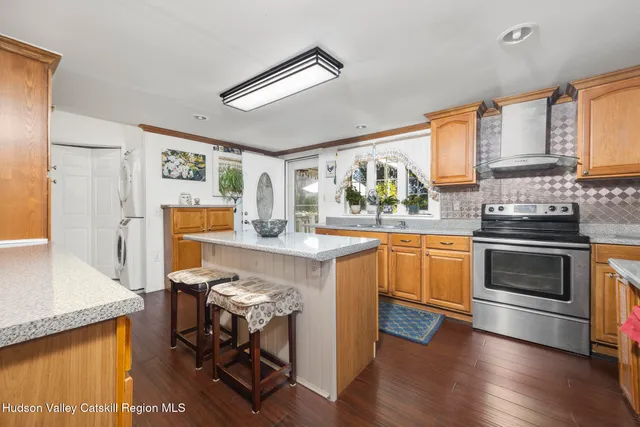 a kitchen with granite countertop a stove top oven a sink dishwasher and a refrigerator