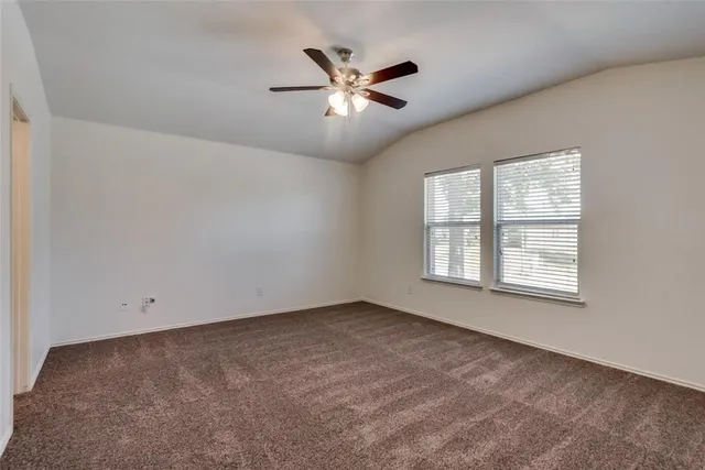 an empty room with fan and windows