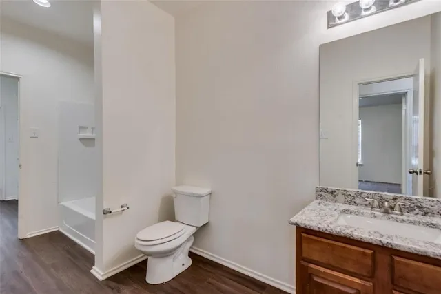 a bathroom with a granite countertop toilet and a sink