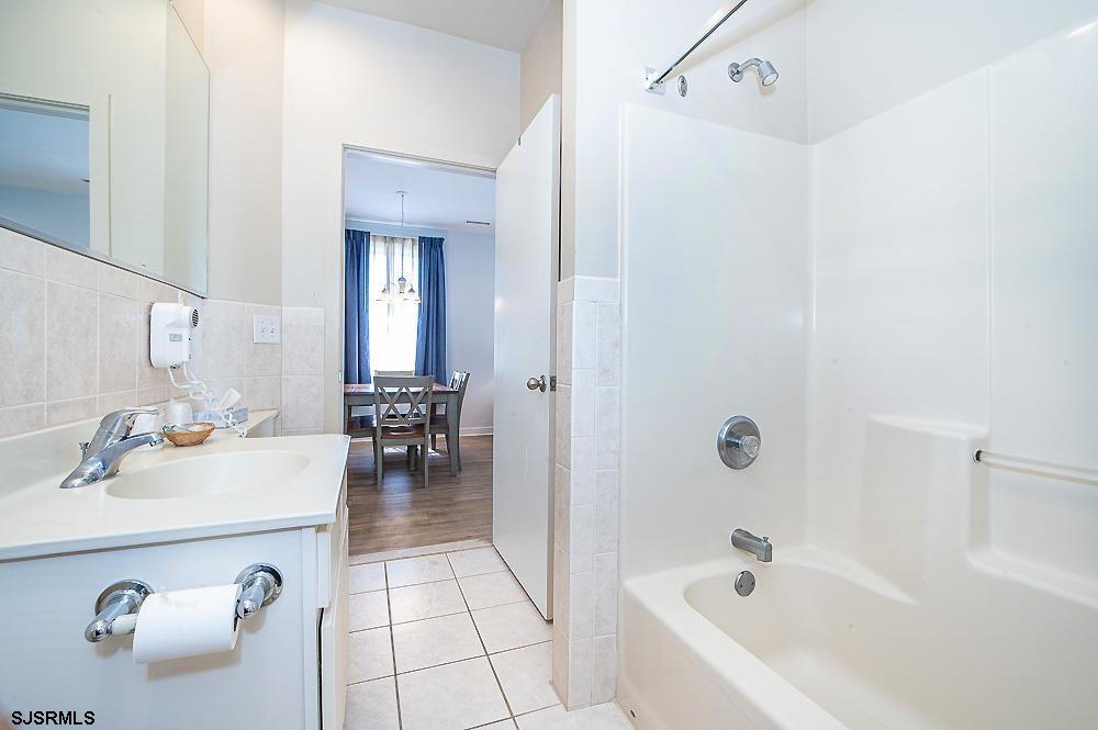 1001 Little Atlantic Avenue, Unit 373 Ocean City, NJ 08226 - Photo 16 of 27 a bathroom with a tub a sink and a mirror