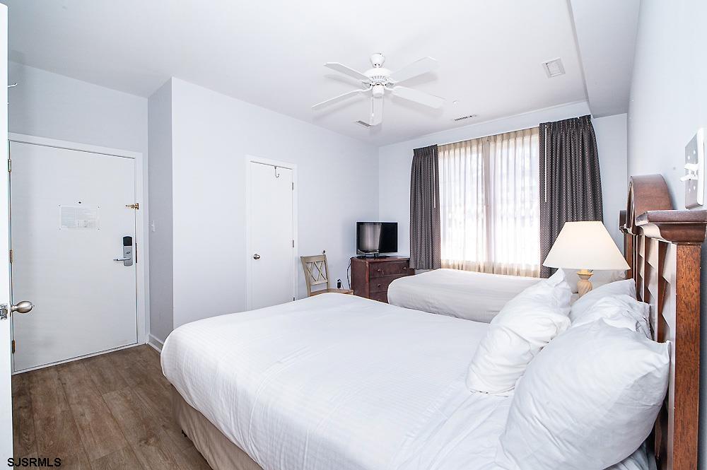 1001 Little Atlantic Avenue, Unit 373 Ocean City, NJ 08226 - Photo 17 of 27 a bedroom with a bed and a chandelier