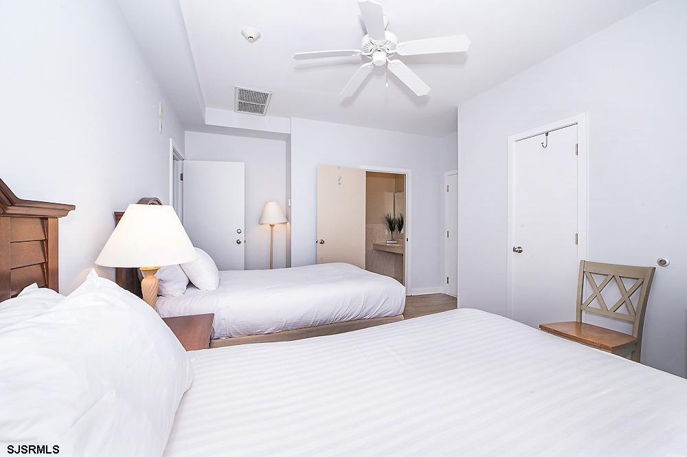 1001 Little Atlantic Avenue, Unit 373 Ocean City, NJ 08226 - Photo 19 of 27 a bedroom with bed and a chandelier