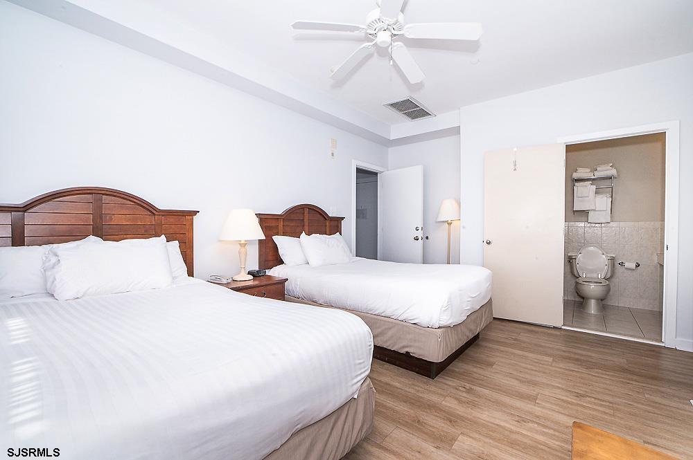 1001 Little Atlantic Avenue, Unit 373 Ocean City, NJ 08226 - Photo 20 of 27 a bedroom with two beds and a chandelier