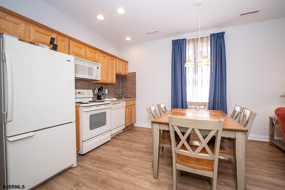 1001 Little Atlantic Avenue, Unit 373 Ocean City, NJ 08226 - Photo 2 of 27 a kitchen with a table chairs a sink dishwasher refrigerator and cabinets