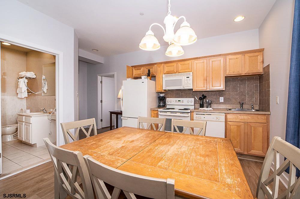 1001 Little Atlantic Avenue, Unit 373 Ocean City, NJ 08226 - Photo 4 of 27 a large kitchen with kitchen island a large counter space dining table and stainless steel appliances