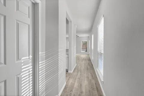 a view of a hallway with wooden floor and staircase