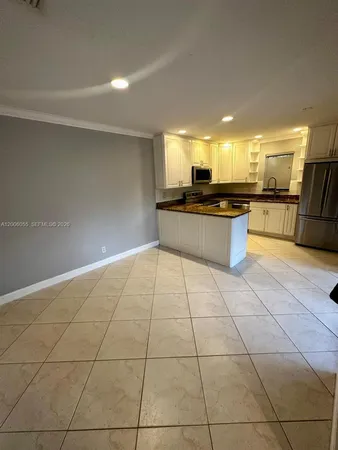 a large white kitchen with a large window and view kitchen