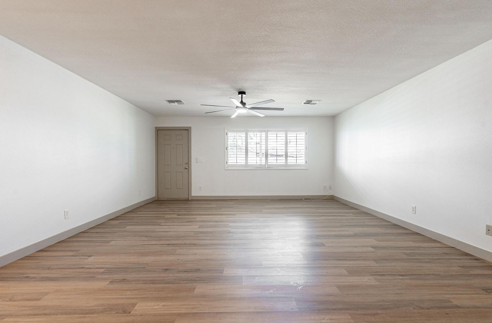 5739 West Monte Vista Road Phoenix, AZ 85035 - Photo 8 of 23 an empty room with wooden floor and windows