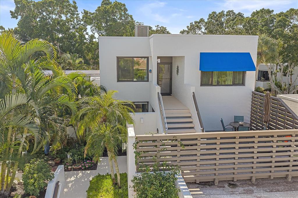 a view of house with a yard and potted plants