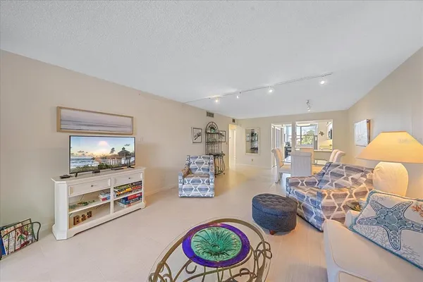 a living room with furniture a flat screen tv and a large window